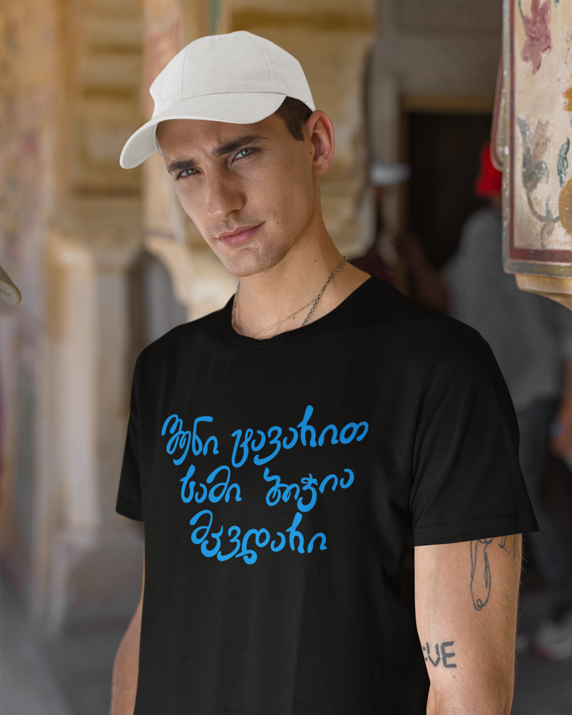 მაისური „შენი ტავარით სამი ბიჭია მკვდარი“ — ცისფერი ხელნაწერი ქართული ფრაზა